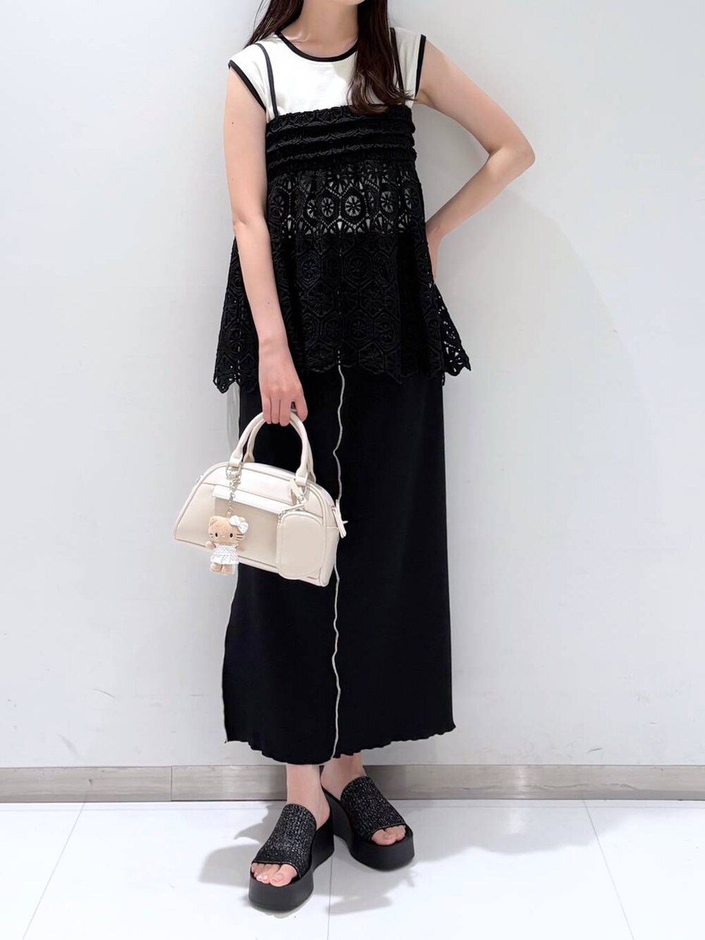 ブラック系のサンダル、ブラック系のキャミソール、ホワイト系のショルダーバッグを着用したレディースの夏コーディネートの3枚目の写真