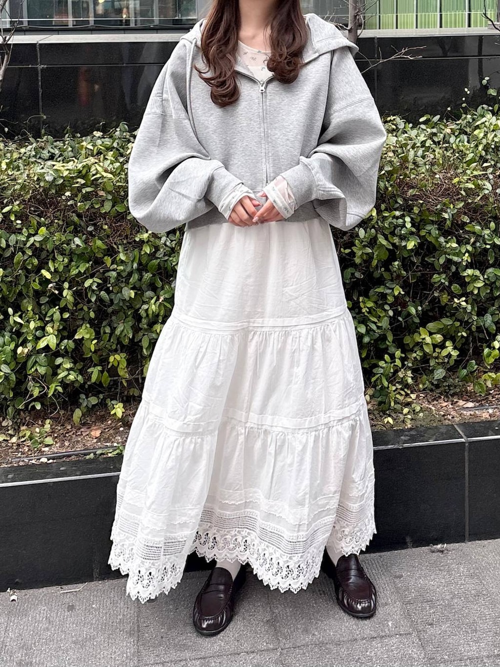 グレー系のパーカー、ホワイト系のTシャツ/カットソー、ブラウン系のローファーを着用したレディースの冬コーディネートの6枚目の写真