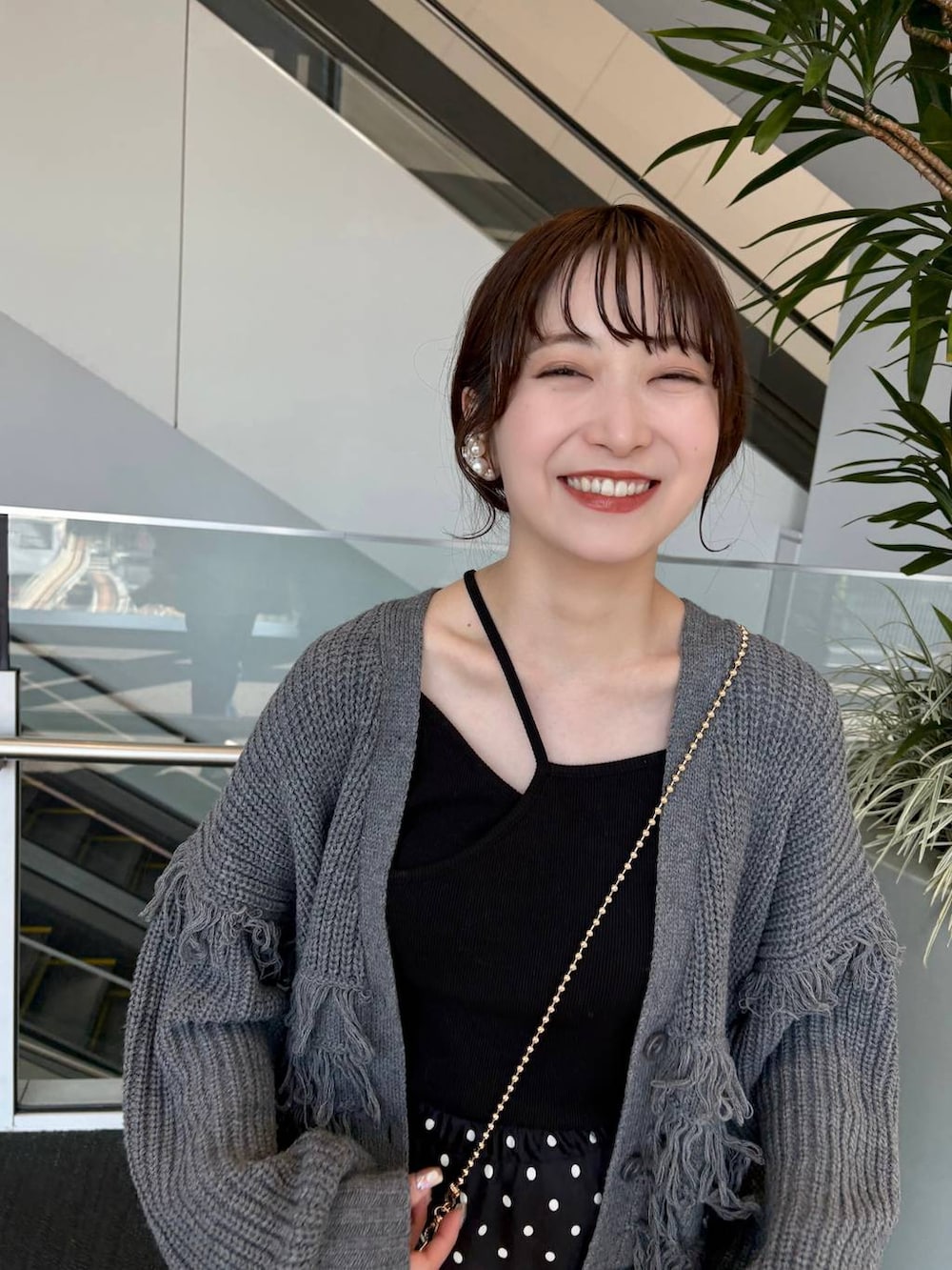 ゴールド系のショルダーバッグ、ブラック系のスカートを着用したレディースの春コーディネートの8枚目の写真