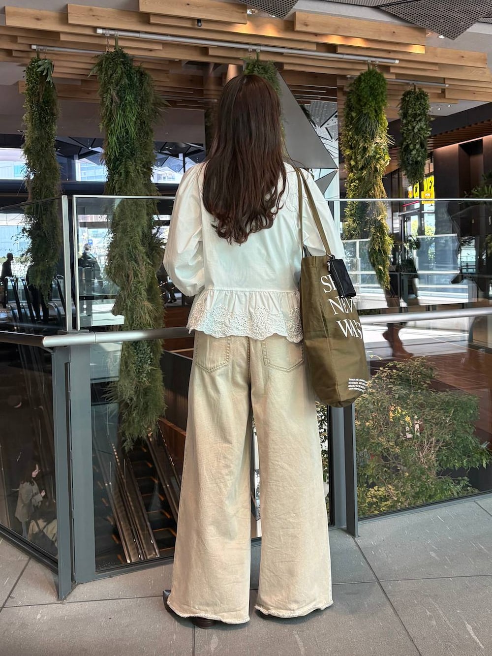 オレンジ系のデニムパンツ、ホワイト系のシャツ/ブラウス、ブラウン系のサンダルを着用したレディースの春コーディネートの4枚目の写真