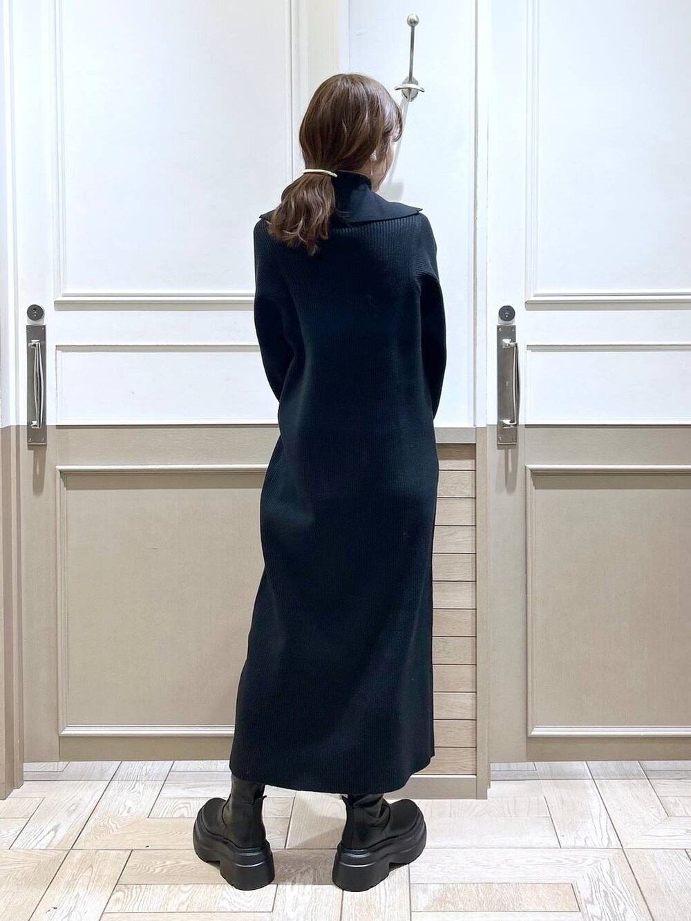 ホワイト系のTシャツ/カットソー、グリーン系のダウンジャケット/コート、ブラック系のブーツを着用したレディースの冬コーディネートの7枚目の写真