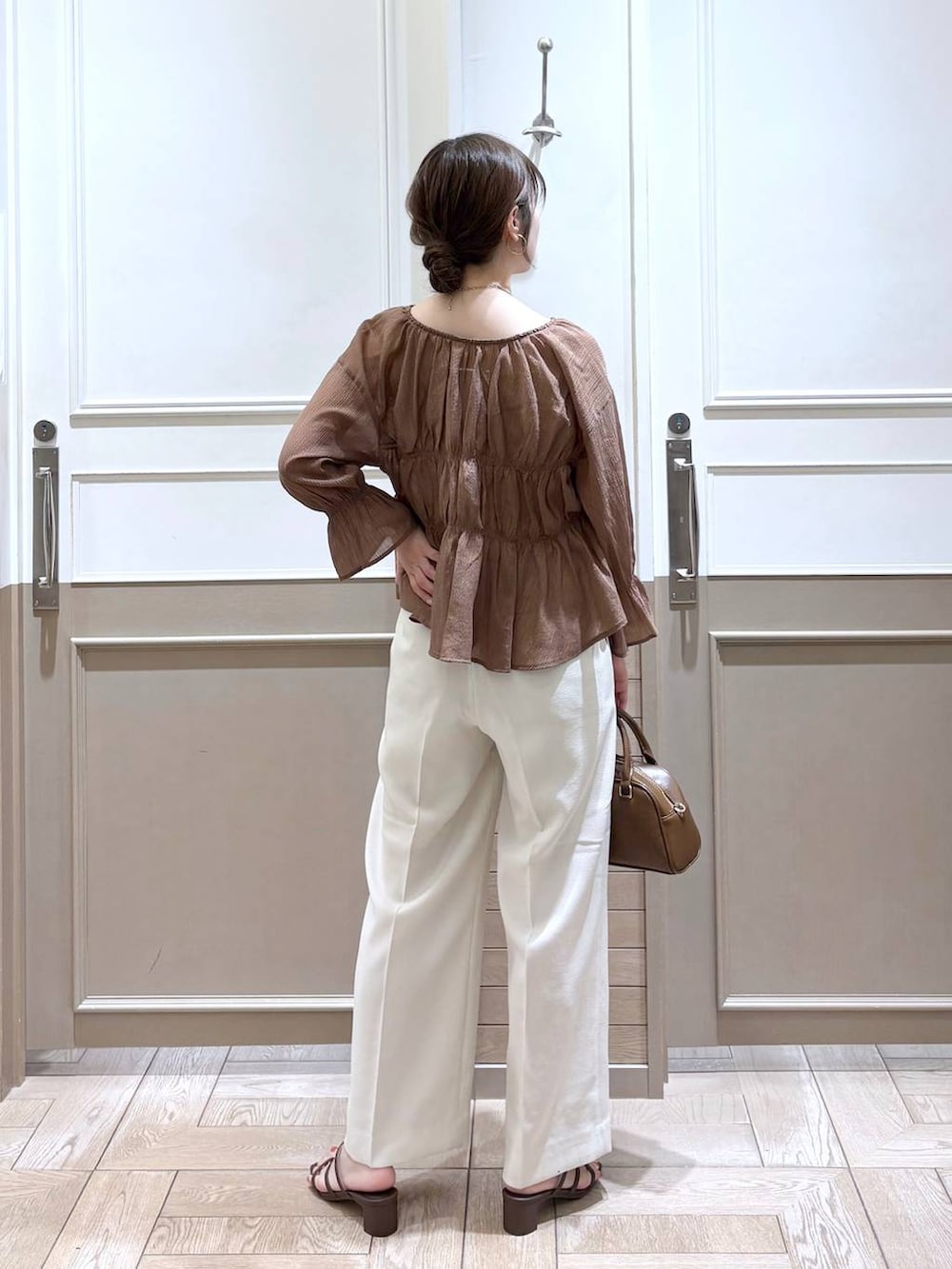 ホワイト系のスラックス、ブラウン系のシャツ/ブラウス、ゴールド系のタンクトップを着用したレディースの夏コーディネートの5枚目の写真