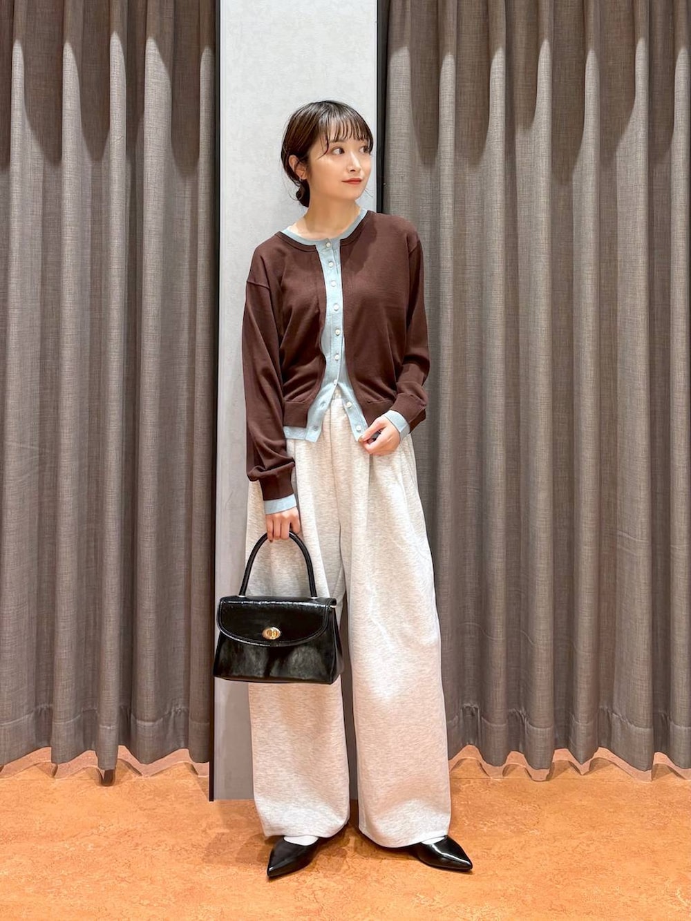 グレー系のスウェットパンツ、ブラック系のボストンバッグ、ブラック系のパンプスを着用したレディースの秋コーディネートの2枚目の写真