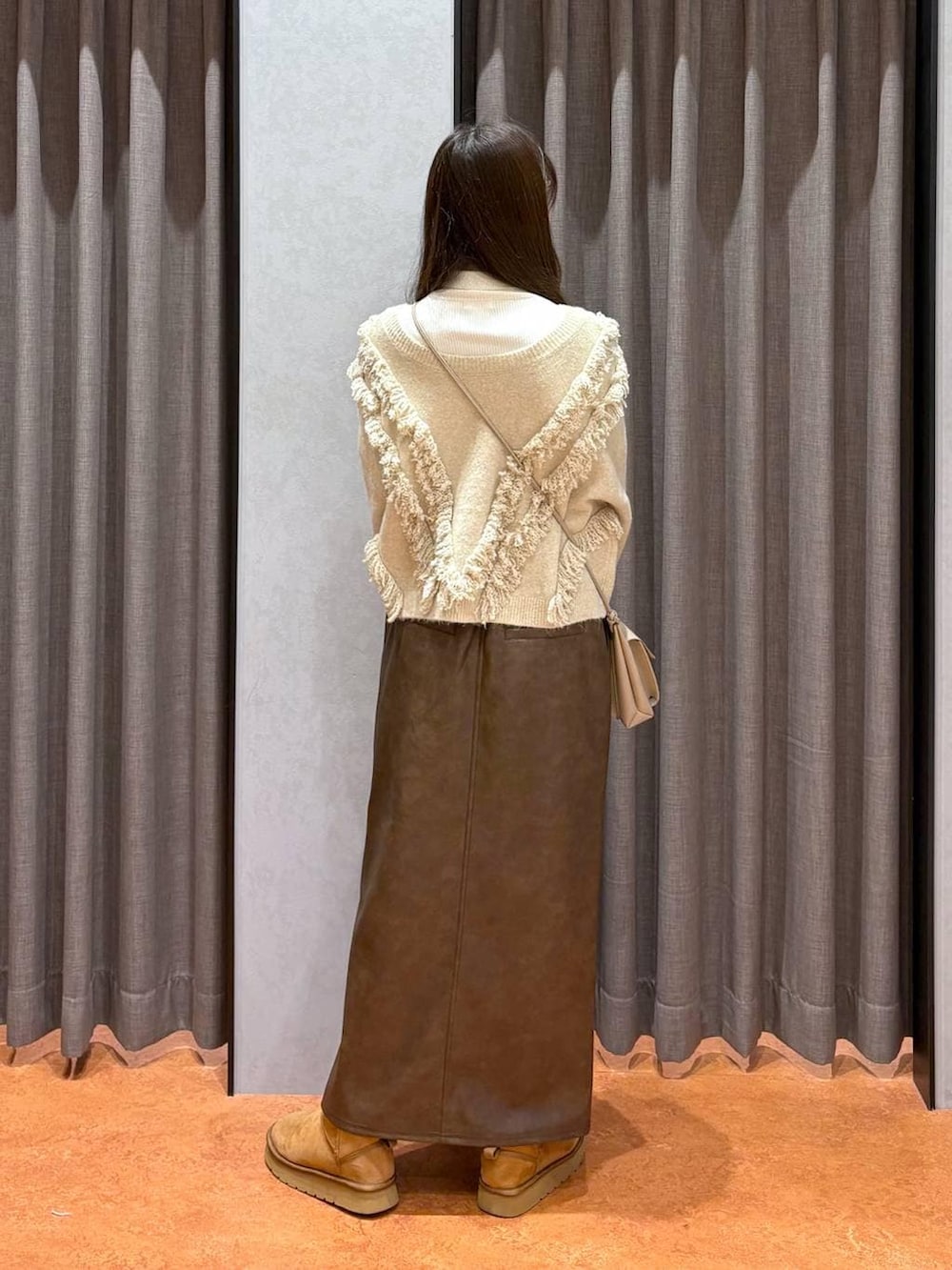 ホワイト系のニット/セーター、ホワイト系のその他アウター、ブラウン系のスカートを着用したレディースの冬コーディネートの6枚目の写真