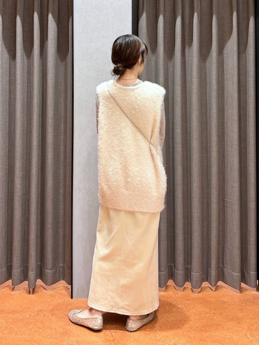 ゴールド系のショルダーバッグ、ホワイト系のスカート、ホワイト系のTシャツ/カットソーを着用したレディースの秋コーディネートの4枚目の写真