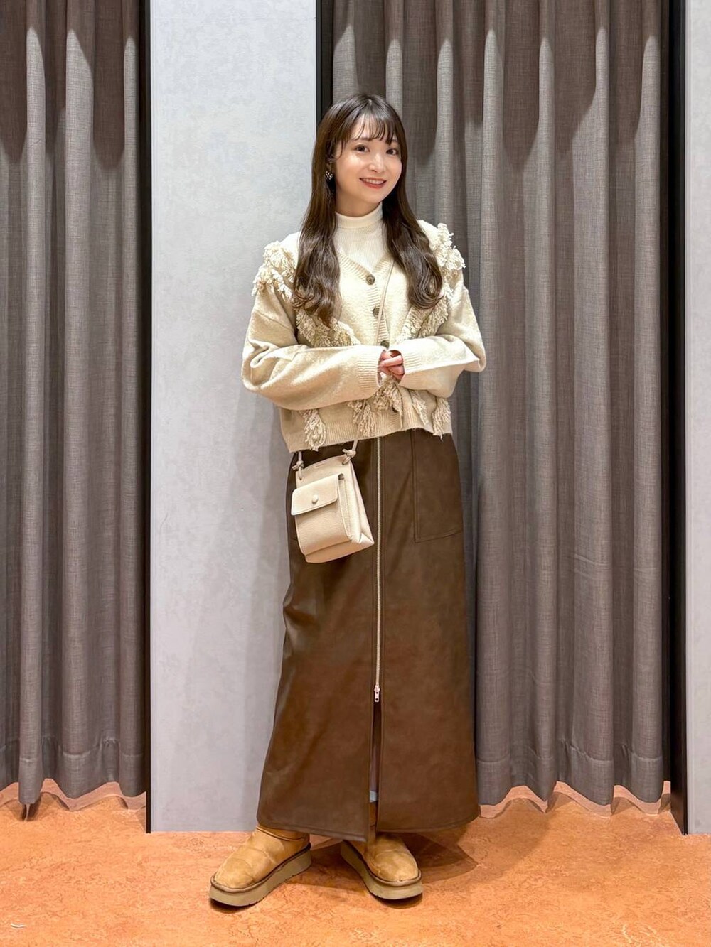 ホワイト系のニット/セーター、ホワイト系のその他アウター、ブラウン系のスカートを着用したレディースの冬コーディネートの4枚目の写真