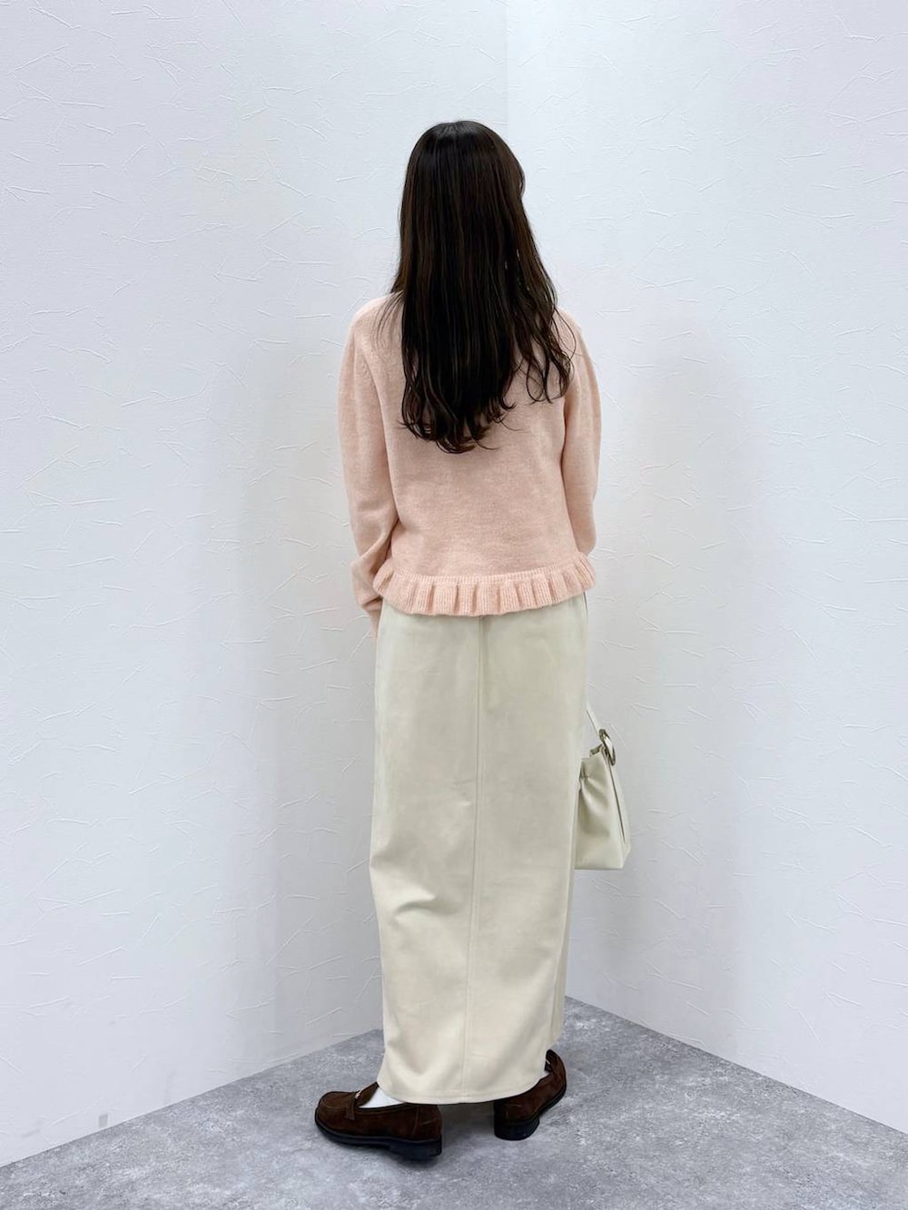 ホワイト系のスカート、ブラウン系のローファー、ホワイト系のショルダーバッグを着用したレディースの秋コーディネートの4枚目の写真