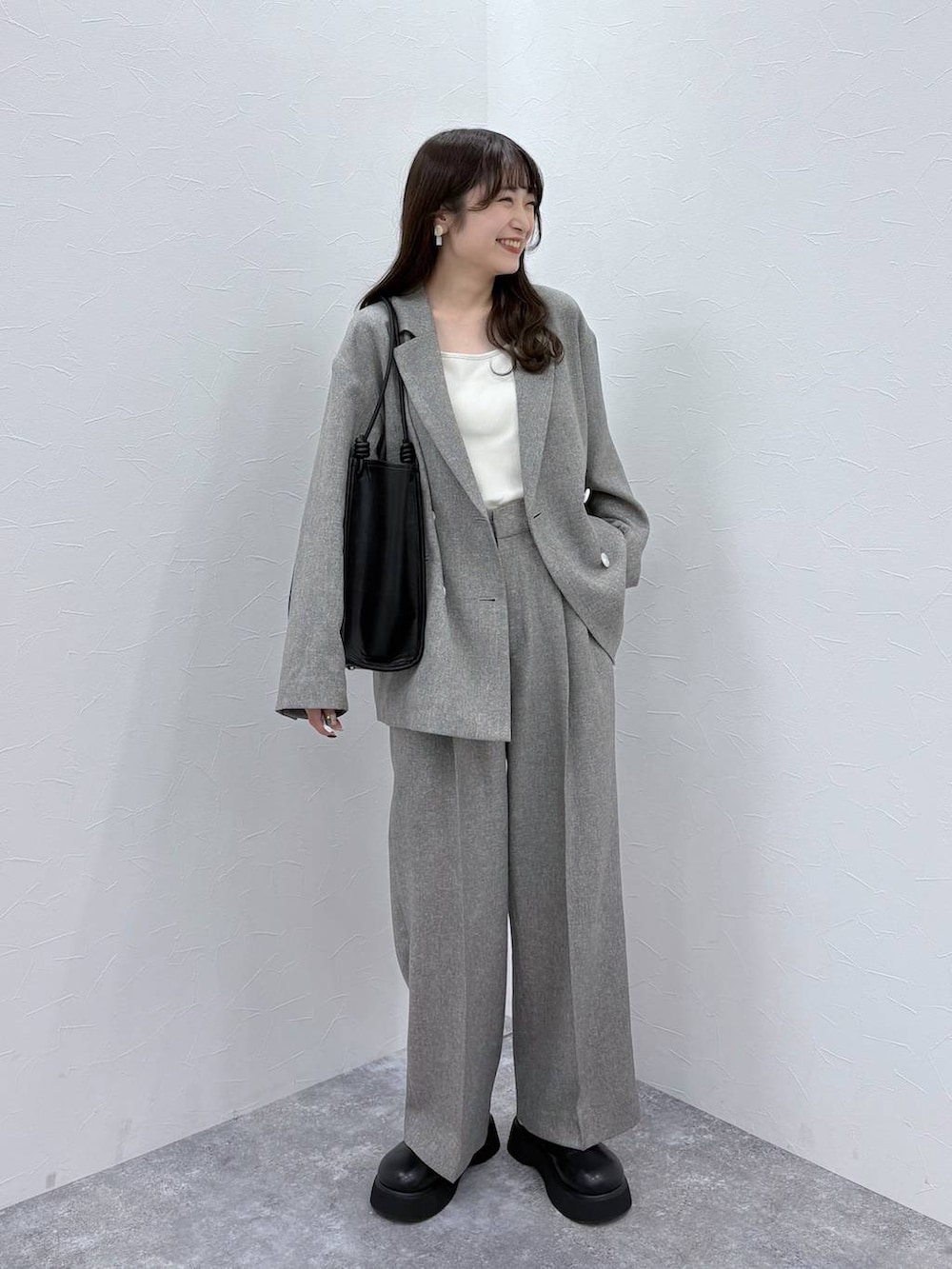 ホワイト系のTシャツ/カットソー、ブラック系のサンダル、グレー系のデニムパンツを着用したレディースの冬コーディネートの2枚目の写真