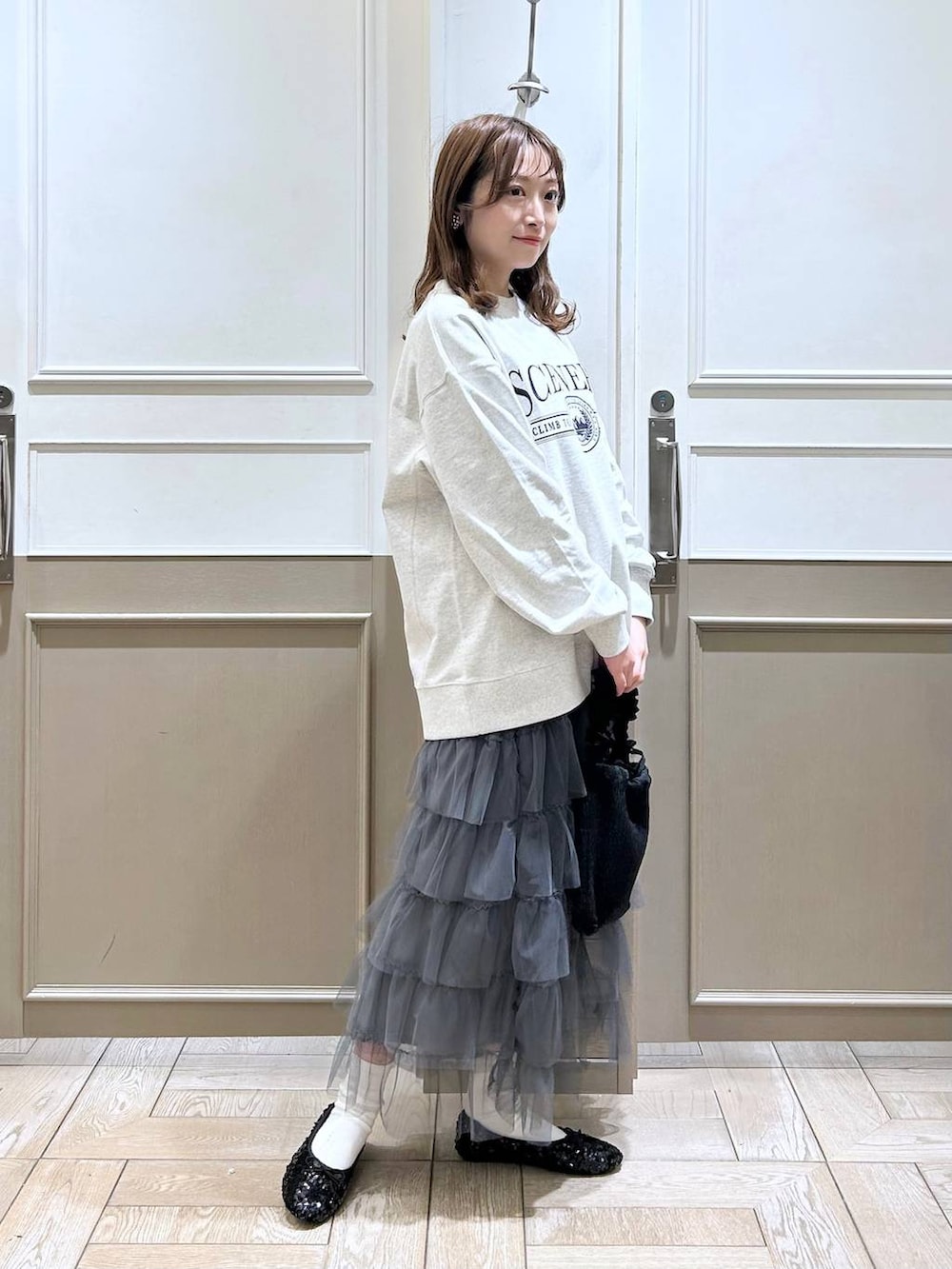 ブラック系のショルダーバッグ、グレー系のスカート、グレー系のスウェットを着用したレディースの冬コーディネートの3枚目の写真