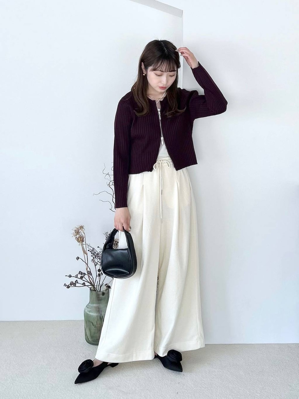 ブラック系のパンプス、ホワイト系のキャミソール、ブラック系のショルダーバッグを着用したレディースの夏コーディネートの3枚目の写真