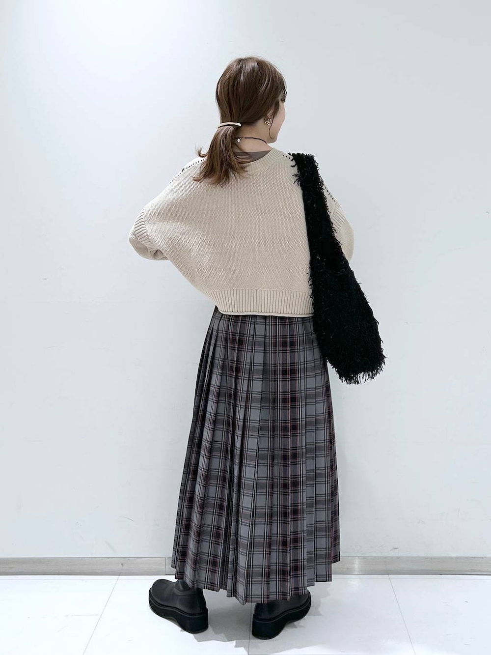 ホワイト系のTシャツ/カットソー、ブラック系のブーツ、ブラック系のトートバッグを着用したレディースの冬コーディネートの4枚目の写真