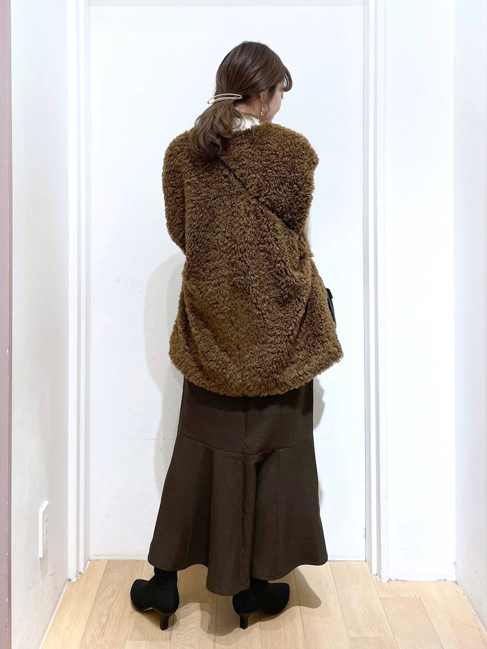 グリーン系のブルゾン、ブラック系のショルダーバッグ、ブラック系のパンプスを着用したレディースの冬コーディネートの2枚目の写真