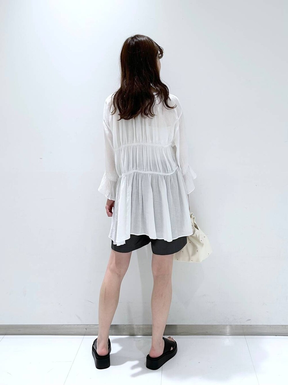 ベージュ系のハンドバッグ、ホワイト系のTシャツ/カットソー、ホワイト系のシャツ/ブラウスを着用したレディースの春コーディネートの6枚目の写真