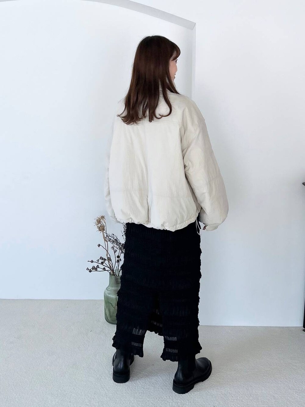 ブラック系のブーツ、ブラック系のスカート、ゴールド系のピアス(両耳用)を着用したレディースの夏コーディネートの3枚目の写真