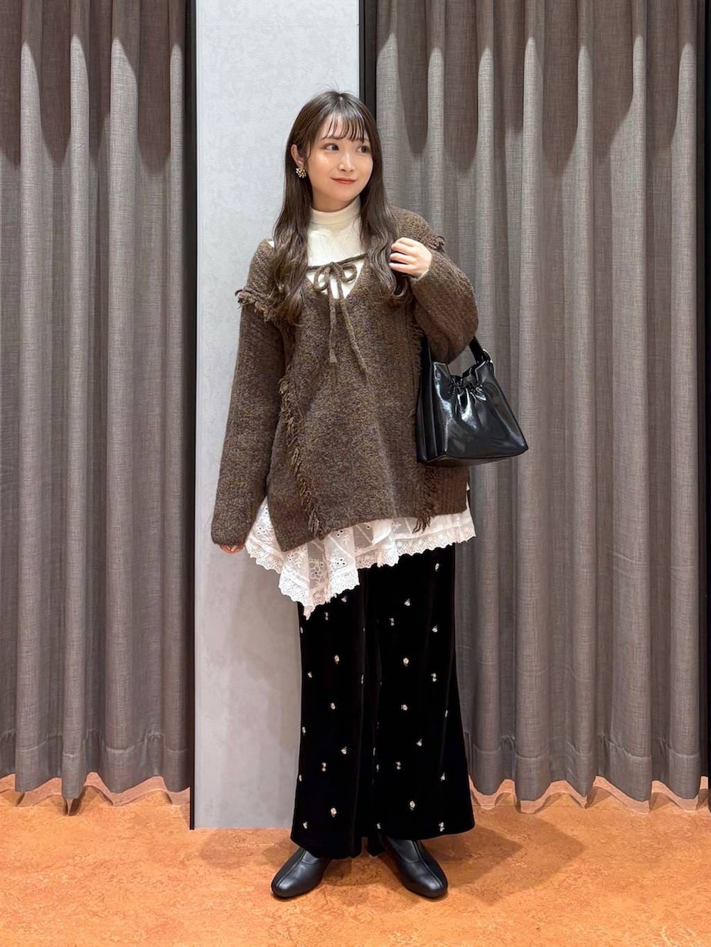 ブラウン系のニット/セーター、ホワイト系のニット/セーター、ブラウン系のムートンコートを着用したレディースの冬コーディネートの5枚目の写真