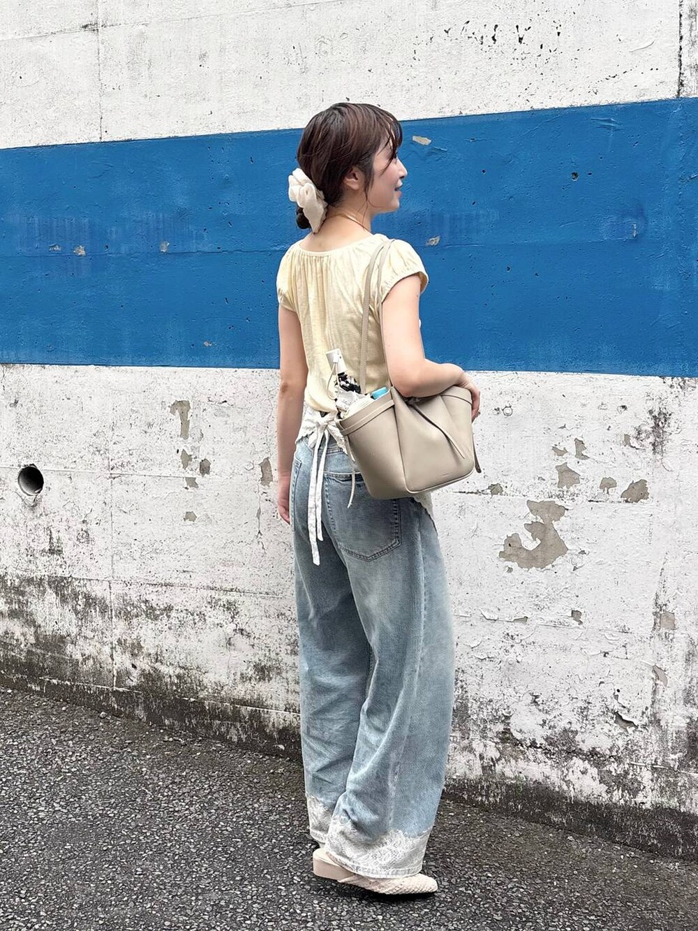 ブルー系のデニムパンツ、ゴールド系のチョーカー、ホワイト系のバンダナ/スカーフを着用したレディースの夏コーディネートの3枚目の写真
