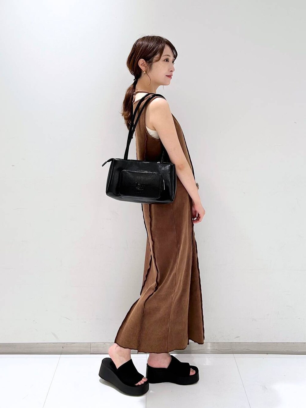 ブラック系のサンダル、ブラウン系のワンピース、ブラック系のショルダーバッグを着用したレディースの夏コーディネートの3枚目の写真