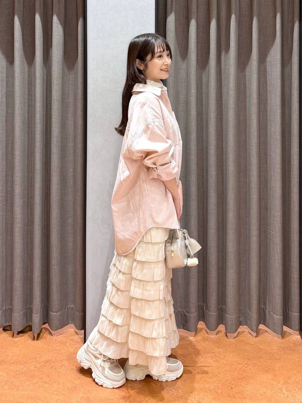 ホワイト系のスカート、ホワイト系のボストンバッグ、ピンク系のシャツ/ブラウスを着用したレディースの冬コーディネートの4枚目の写真