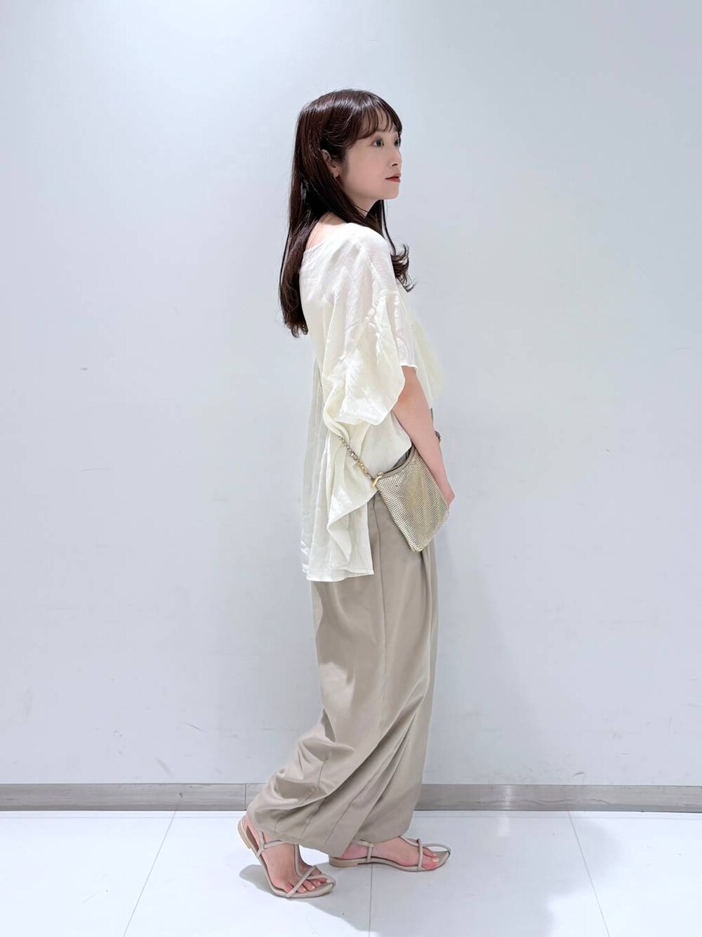 ゴールド系のショルダーバッグ、ホワイト系のサンダル、ベージュ系のその他パンツを着用したレディースの夏コーディネートの3枚目の写真