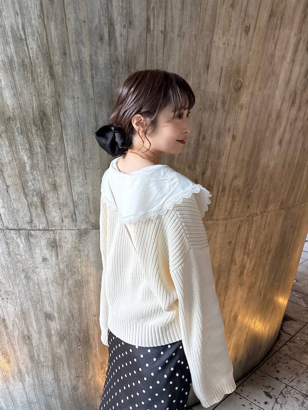 ブラック系のスカート、ブラック系のパンプス、ホワイト系のカーディガン/ボレロを着用したレディースの冬コーディネートの2枚目の写真