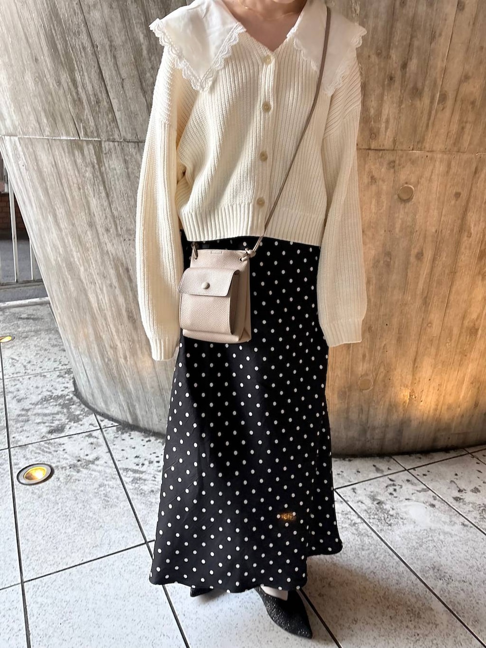 ブラック系のスカート、ブラック系のパンプス、ホワイト系のカーディガン/ボレロを着用したレディースの冬コーディネートの4枚目の写真