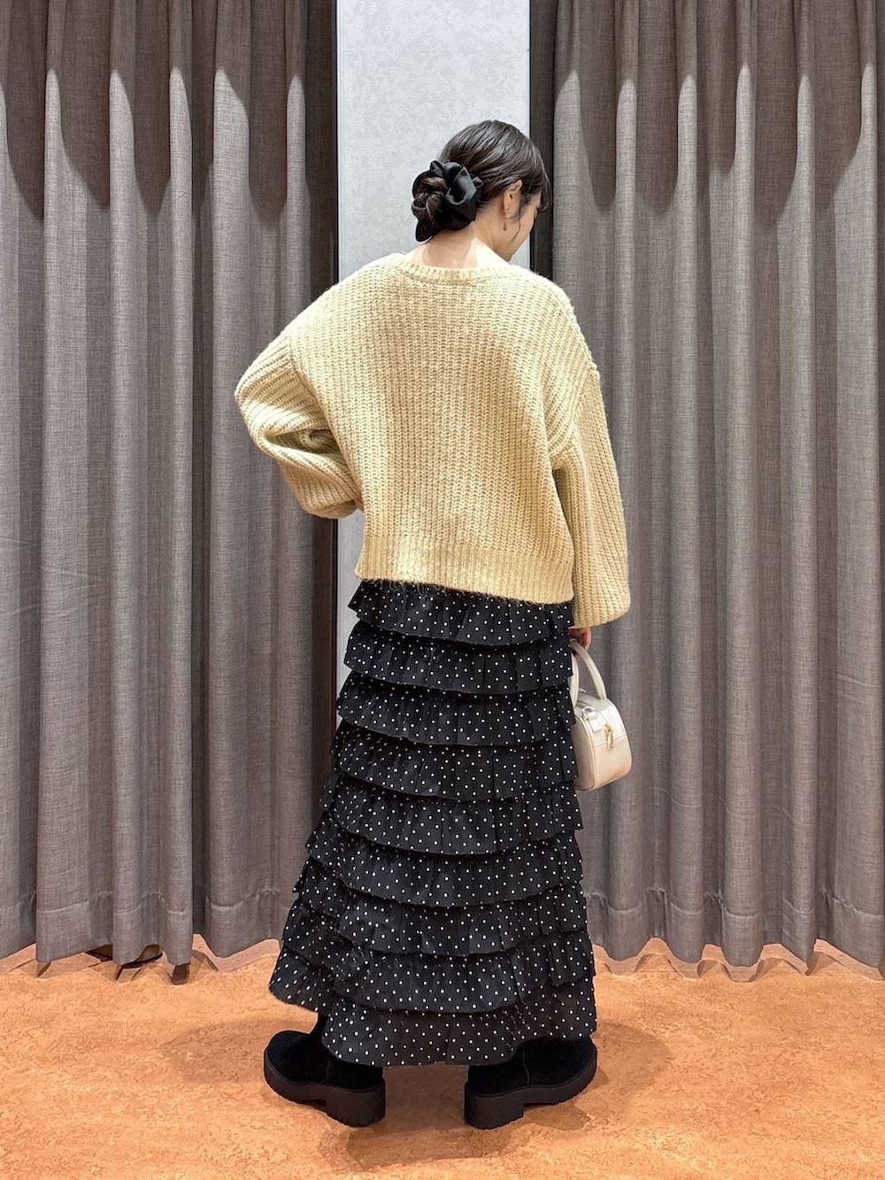 ブラウン系のその他アウター、その他のスカート、ホワイト系のボストンバッグを着用したレディースの冬コーディネートの8枚目の写真