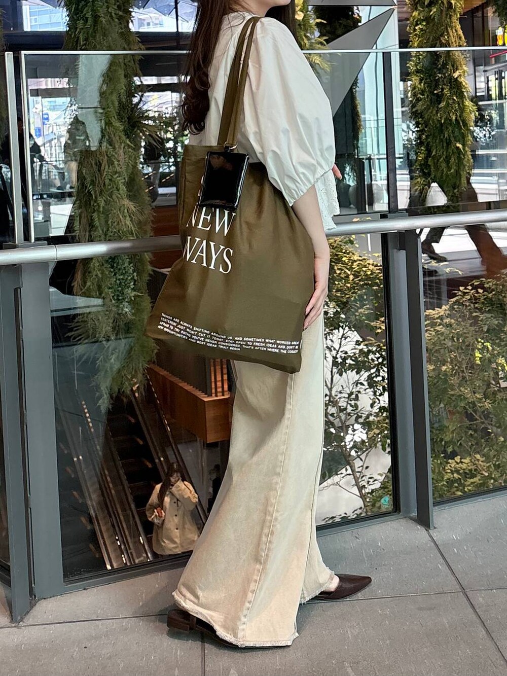 オレンジ系のデニムパンツ、ホワイト系のシャツ/ブラウス、ブラウン系のサンダルを着用したレディースの春コーディネートの3枚目の写真
