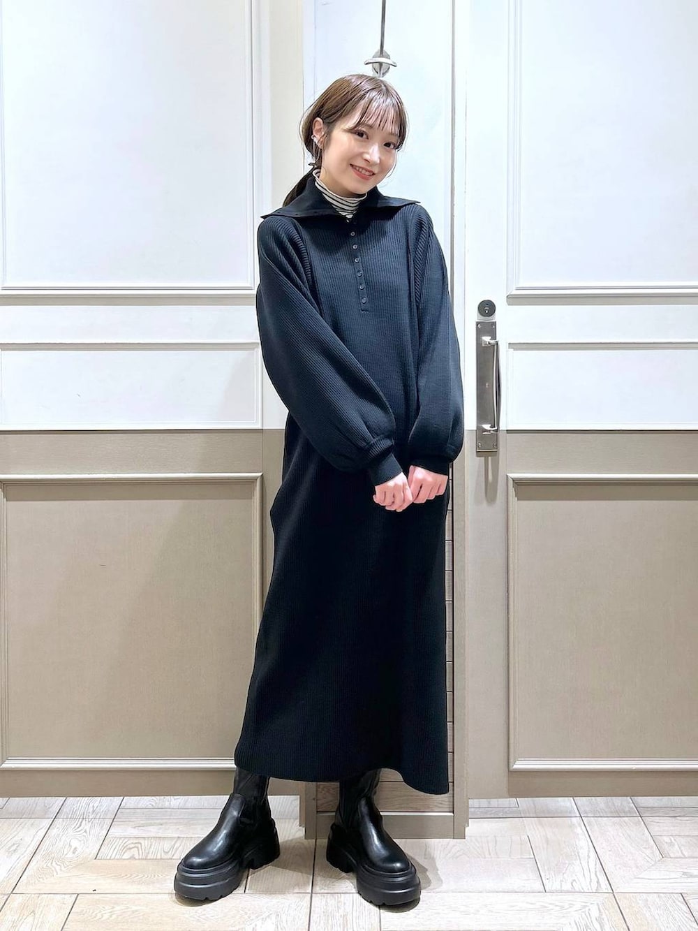 ホワイト系のTシャツ/カットソー、グリーン系のダウンジャケット/コート、ブラック系のブーツを着用したレディースの冬コーディネートの5枚目の写真