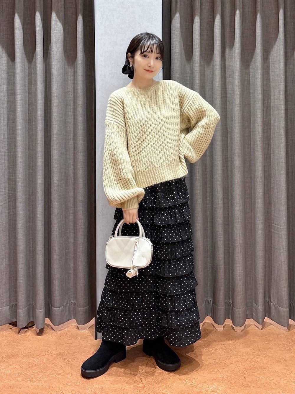 ブラウン系のその他アウター、その他のスカート、ホワイト系のボストンバッグを着用したレディースの冬コーディネートの5枚目の写真