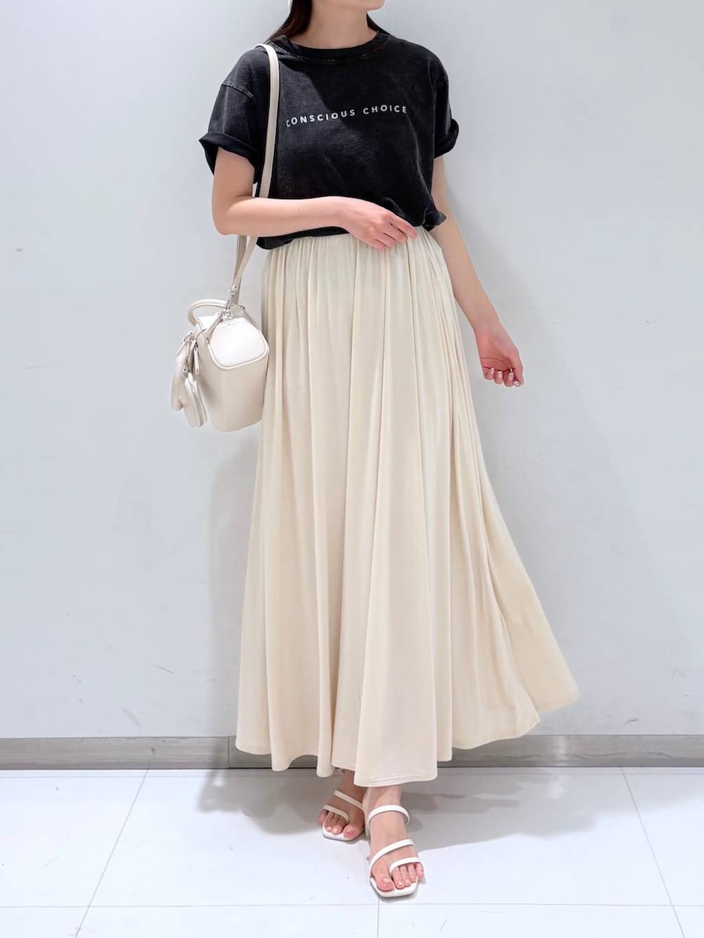 ホワイト系のサンダル、ホワイト系のショルダーバッグ、ホワイト系のスカートを着用したレディースの夏コーディネートの3枚目の写真