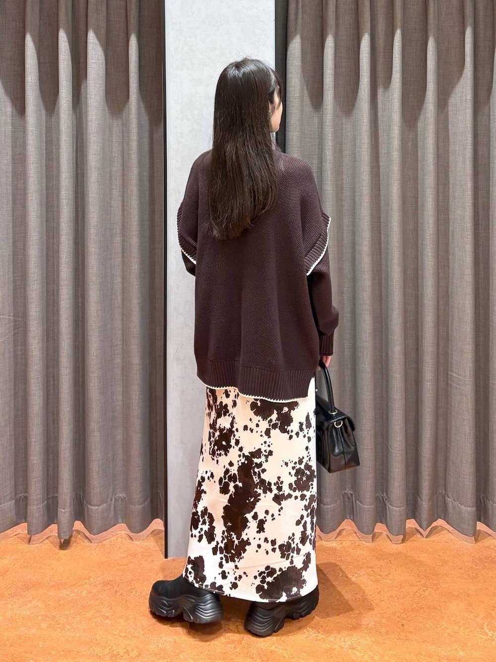 ブラック系のブーツ、その他のスカート、ブラウン系のニット/セーターを着用したレディースの冬コーディネートの8枚目の写真