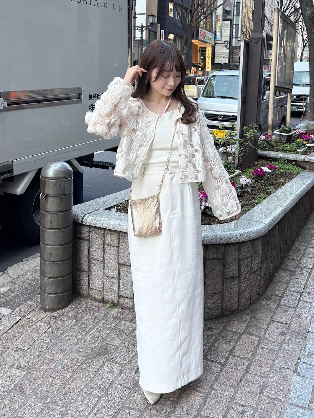 ゴールド系のショルダーバッグ、ホワイト系のパンプスを着用したレディースの春コーディネートの3枚目の写真