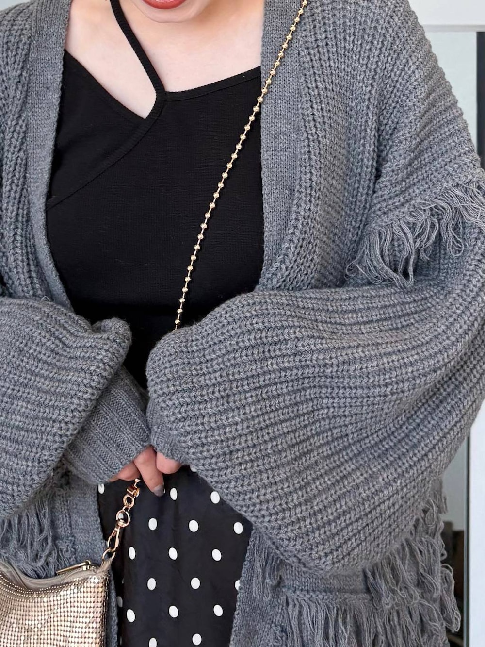 ゴールド系のショルダーバッグ、ブラック系のスカートを着用したレディースの春コーディネートの3枚目の写真