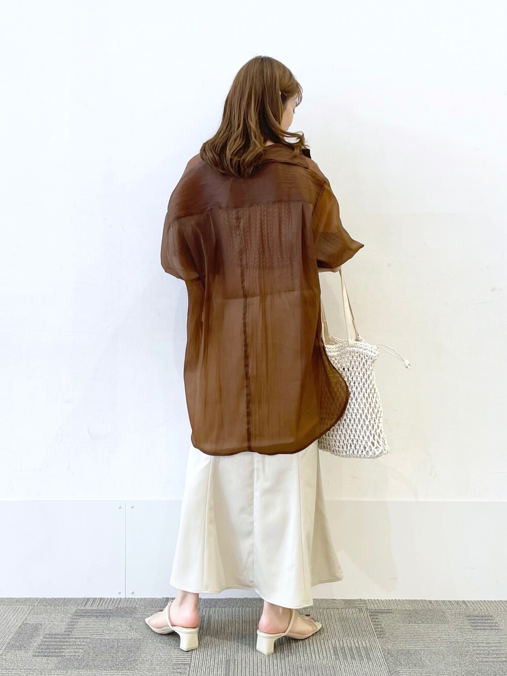 ホワイト系のサンダル、ホワイト系のスカート、ホワイト系のトートバッグを着用したレディースの夏コーディネートの2枚目の写真