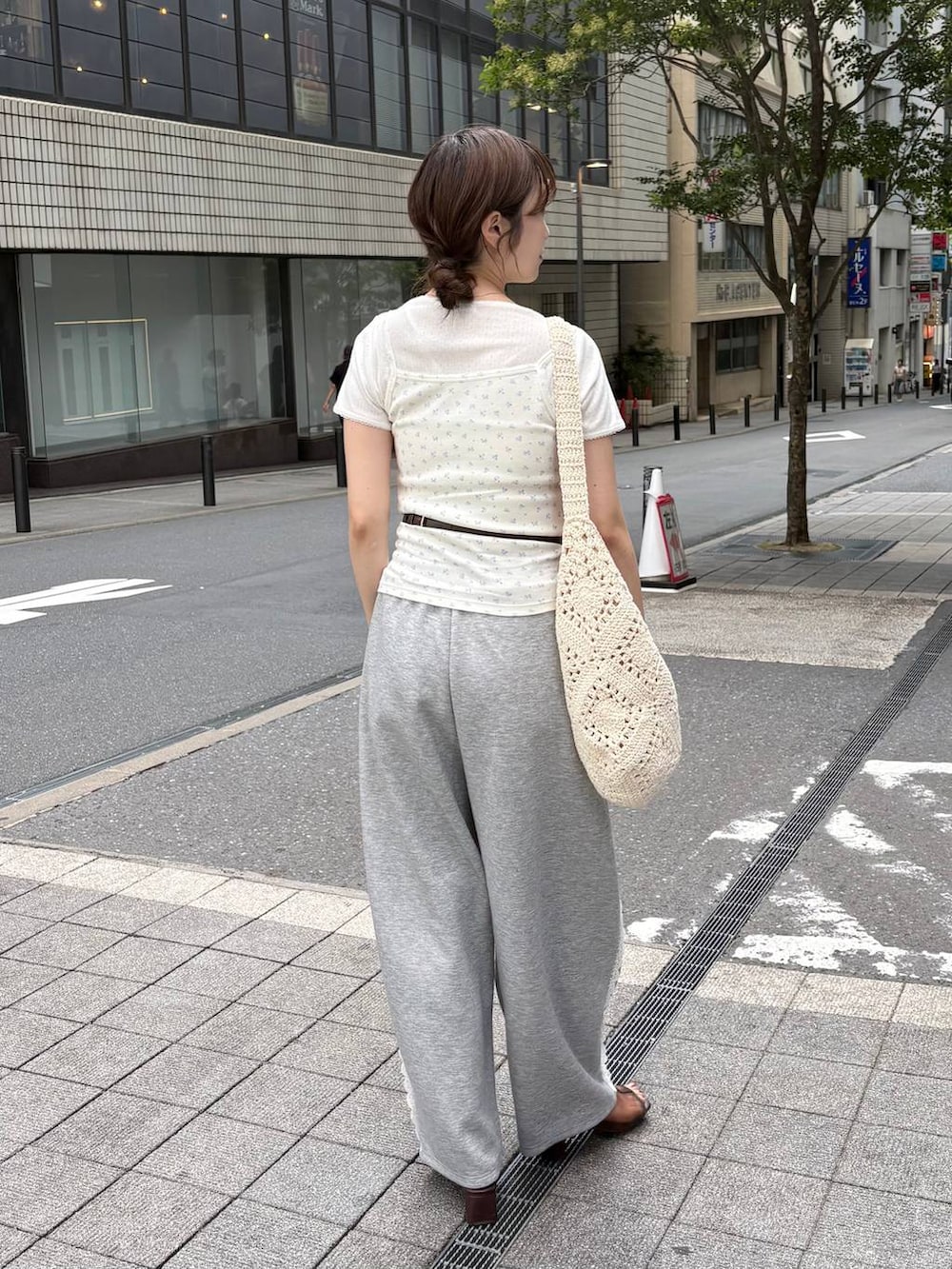 グレー系のスウェットパンツ、ブラウン系のボディバッグ/ウエストポーチ、ブラウン系のサンダルを着用したレディースの夏コーディネートの4枚目の写真