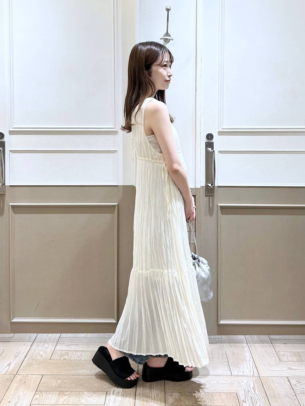 ホワイト系のTシャツ/カットソー、ブラック系のサンダル、ブルー系のデニムパンツを着用したレディースの夏コーディネートの3枚目の写真