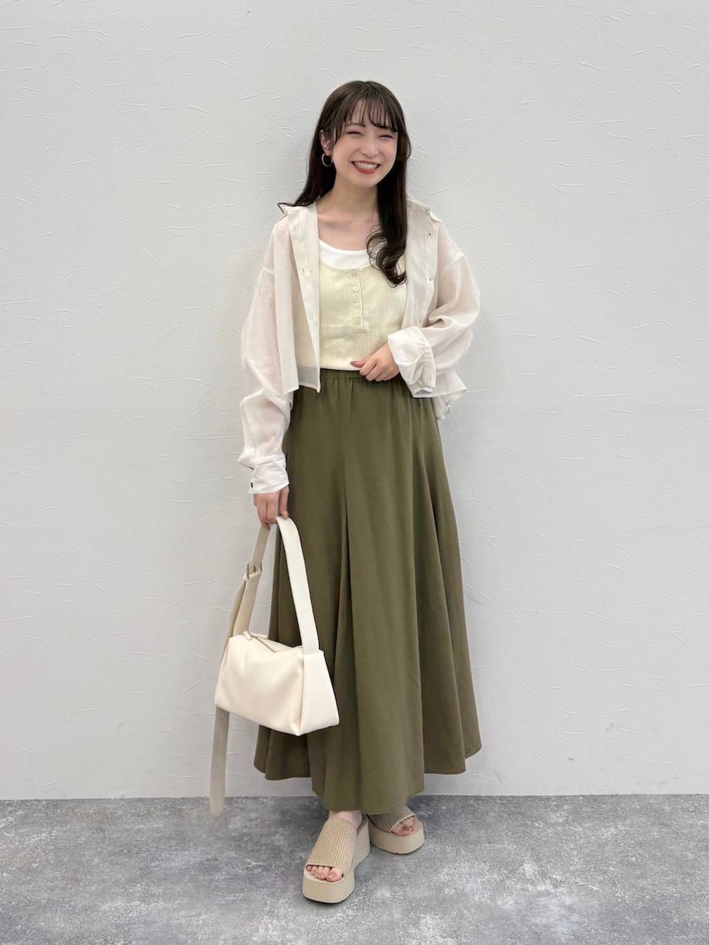 ホワイト系のシャツ/ブラウス、ブラウン系のスカート、ホワイト系のサンダルを着用したレディースの春コーディネートの3枚目の写真