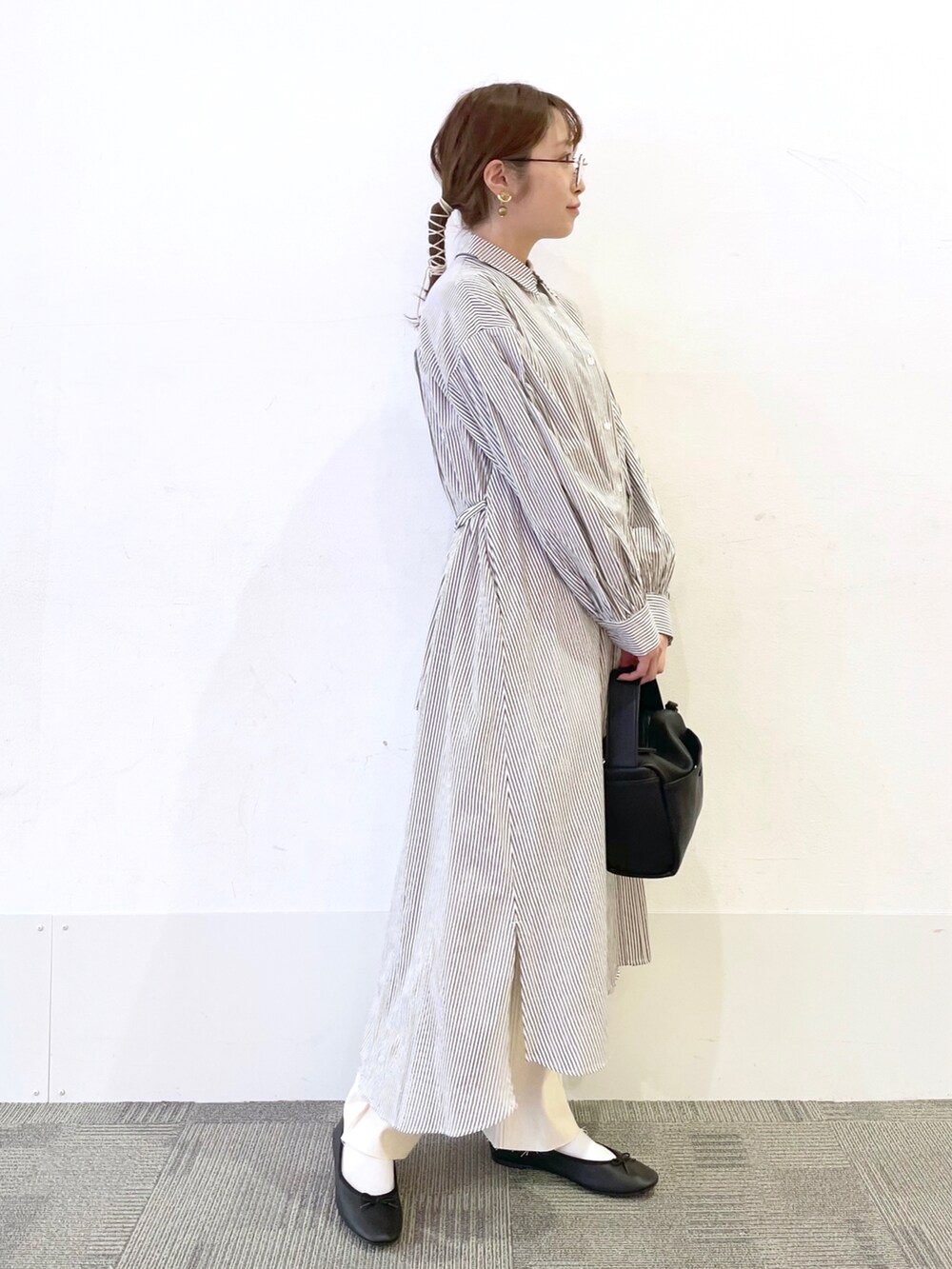 ブラック系のショルダーバッグ、ブラック系のバレエシューズ、ブラウン系のワンピースを着用したレディースの冬コーディネートの2枚目の写真