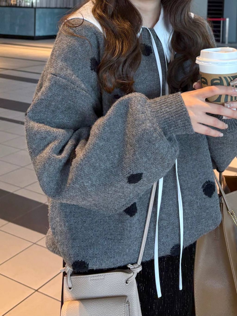 ブラック系のスカート、ホワイト系のシャツ/ブラウス、グレー系のニット/セーターを着用したレディースの冬コーディネートの4枚目の写真