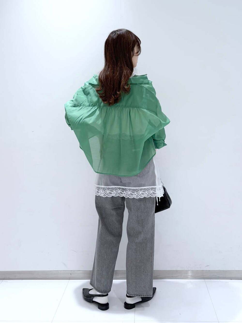 グリーン系のシャツ/ブラウス、グレー系のデニムパンツ、ブラック系のショルダーバッグを着用したレディースの春コーディネートの5枚目の写真