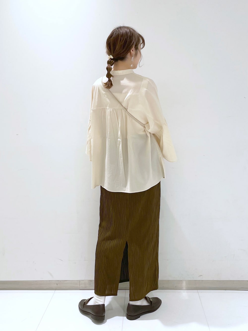 ブラウン系のローファー、ブラウン系のスカート、ホワイト系のシャツ/ブラウスを着用したレディースの春コーディネートの2枚目の写真