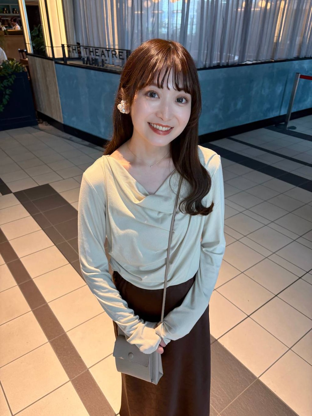 ブラウン系のスカート、ホワイト系のパンプス、ベージュ系のTシャツ/カットソーを着用したレディースの冬コーディネートの4枚目の写真