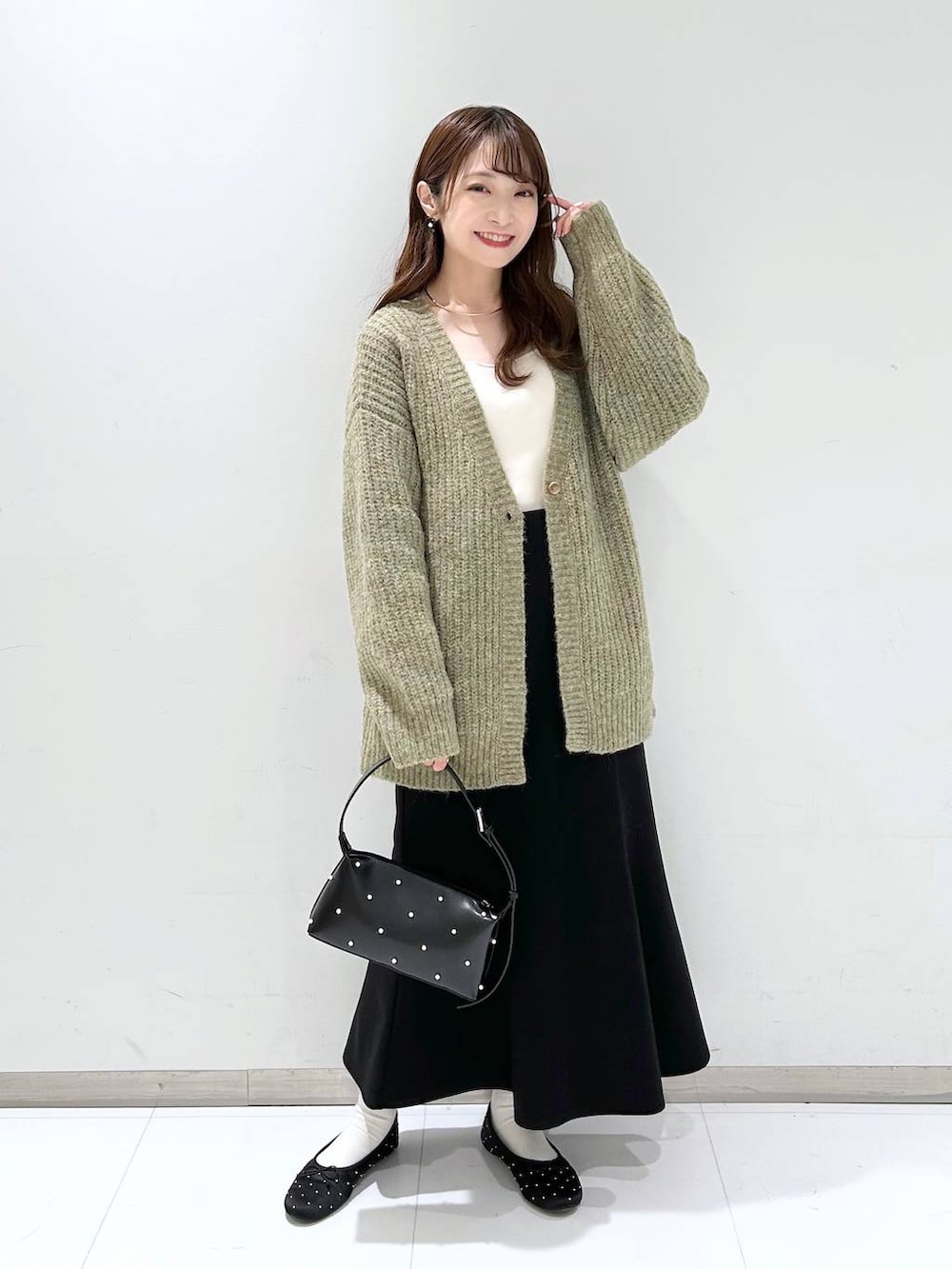 ホワイト系のタンクトップ、ブラック系のバレエシューズ、ブラック系のスカートを着用したレディースの秋コーディネートの2枚目の写真