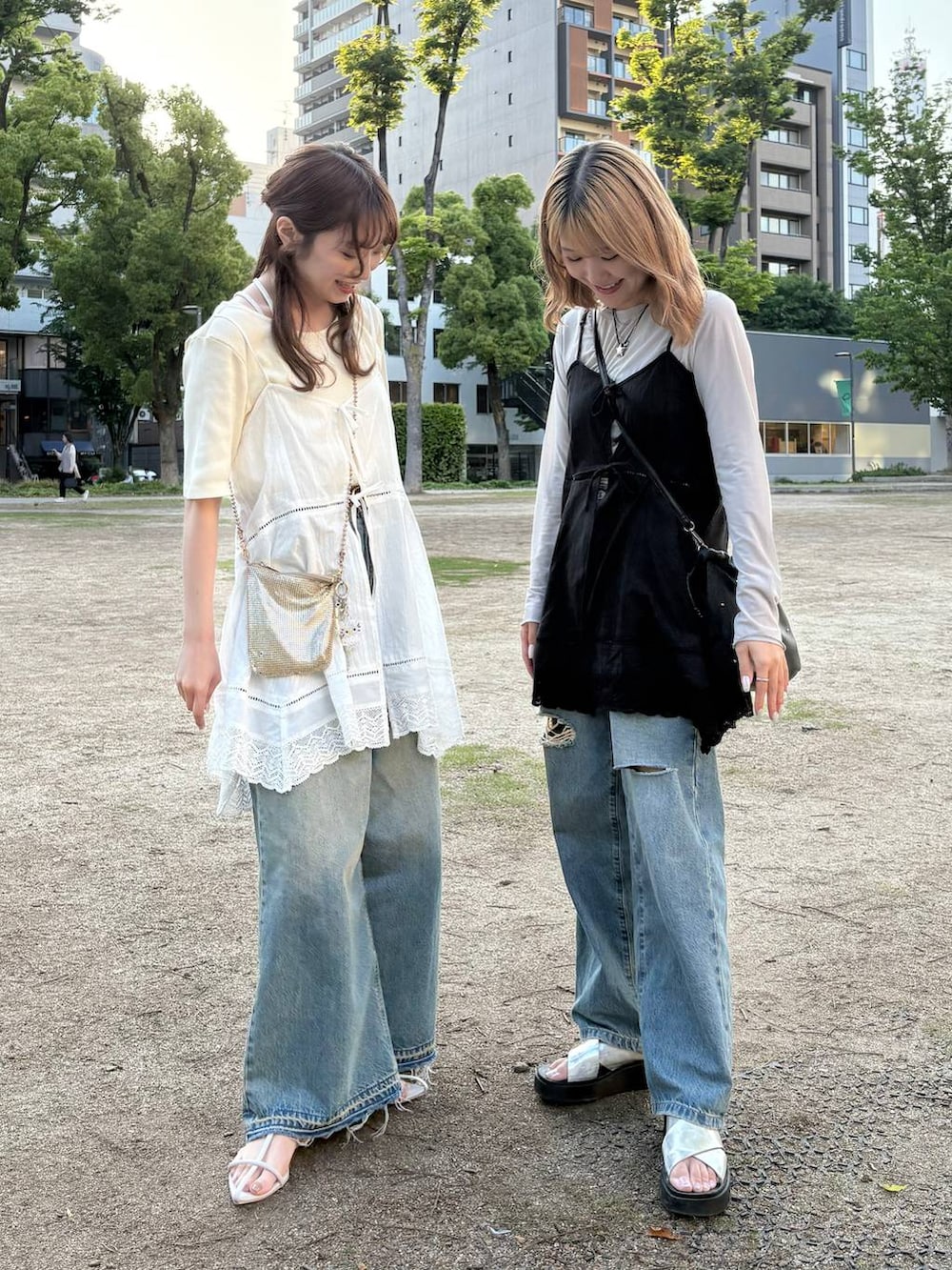 ゴールド系のショルダーバッグ、ホワイト系のサンダル、ブラック系のワンピースを着用したレディースの夏コーディネートの2枚目の写真