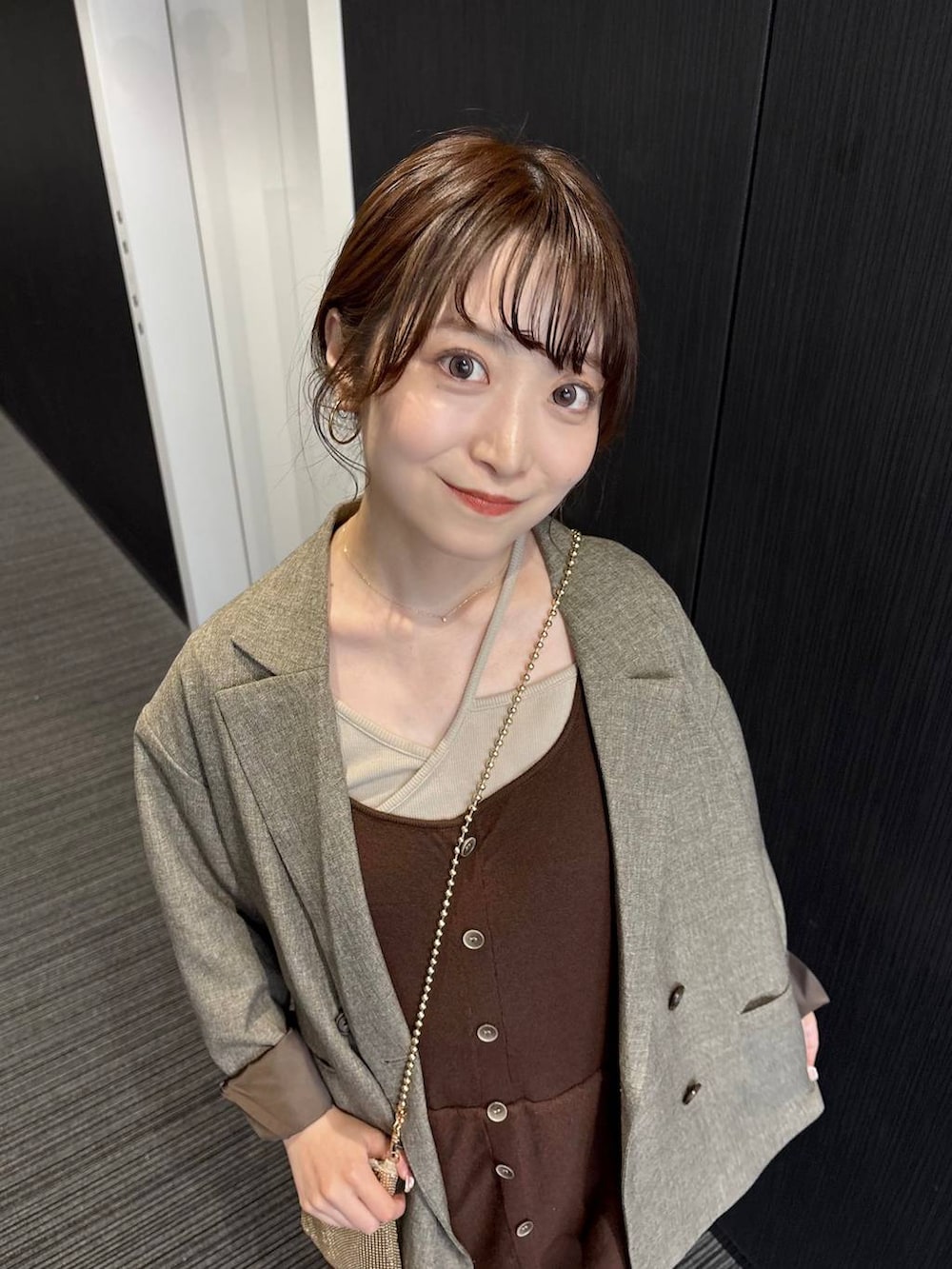 ゴールド系のショルダーバッグ、ブラウン系のテーラードジャケット、ブラウン系のつなぎ/オールインワンを着用したレディースの春コーディネートの6枚目の写真