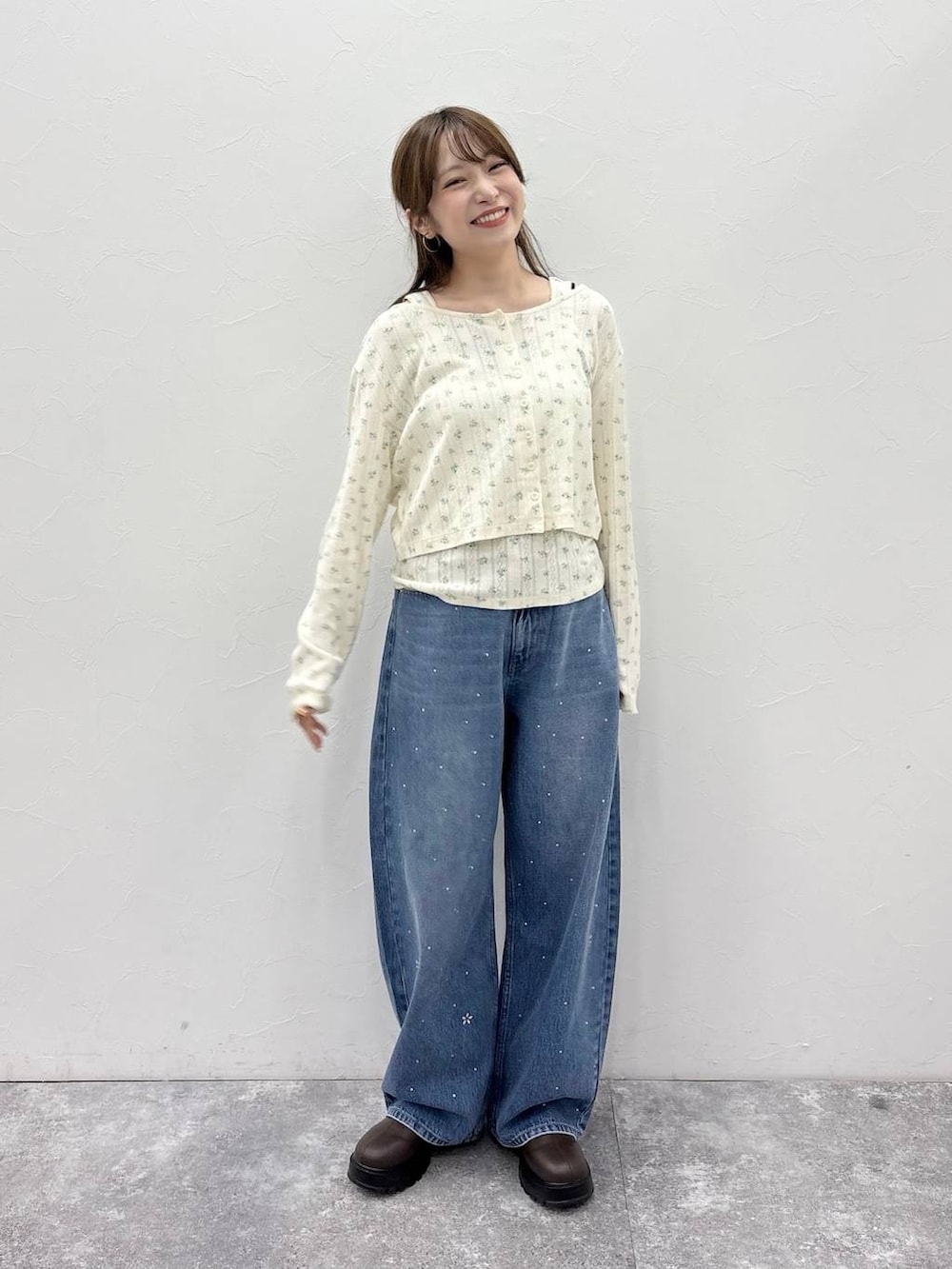 ブラウン系のブーツ、ブルー系のデニムパンツを着用したレディースの秋コーディネートの2枚目の写真