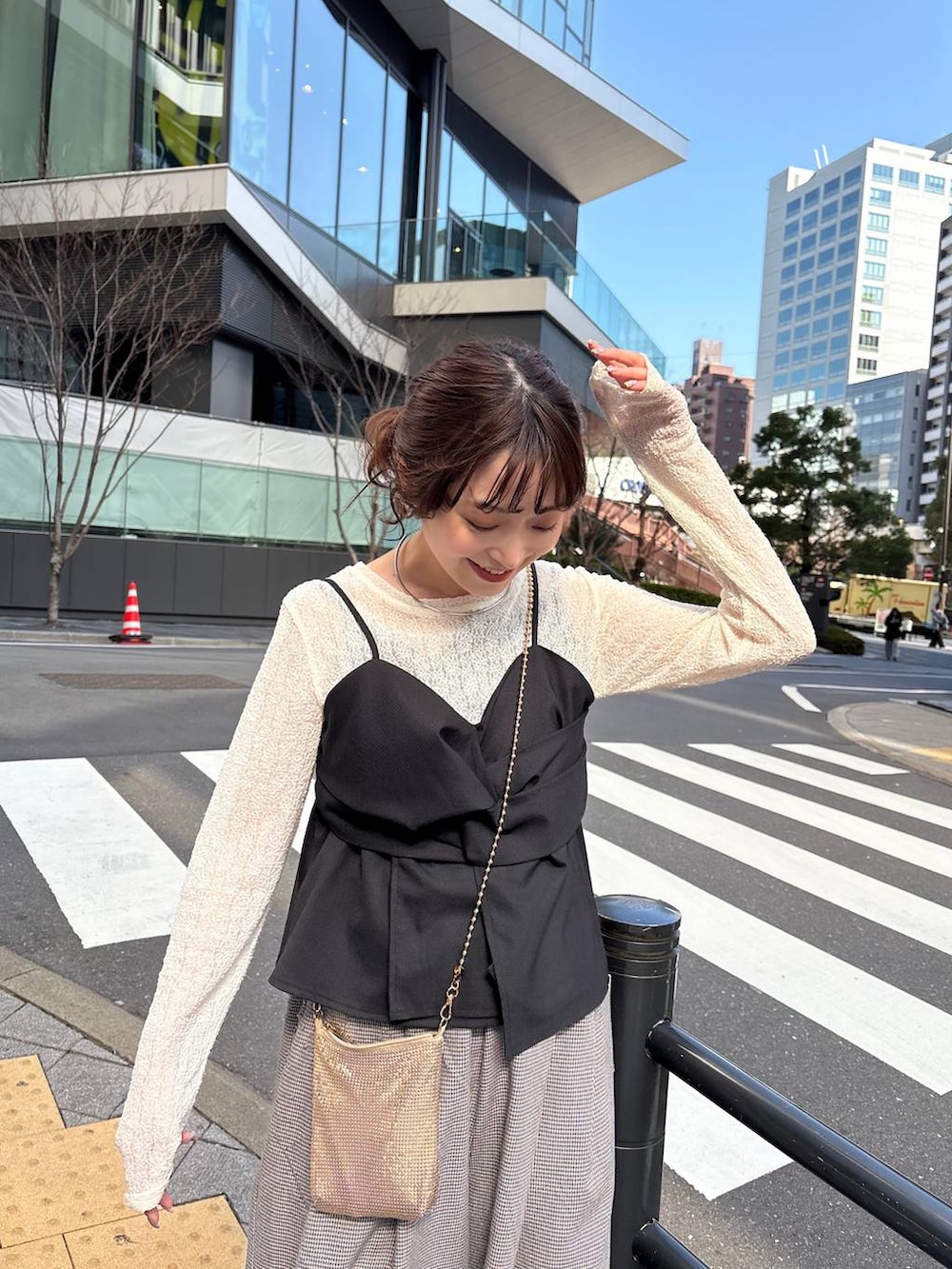 ゴールド系のショルダーバッグ、ブラック系のパンプス、ゴールド系のチョーカーを着用したレディースの春コーディネートの6枚目の写真