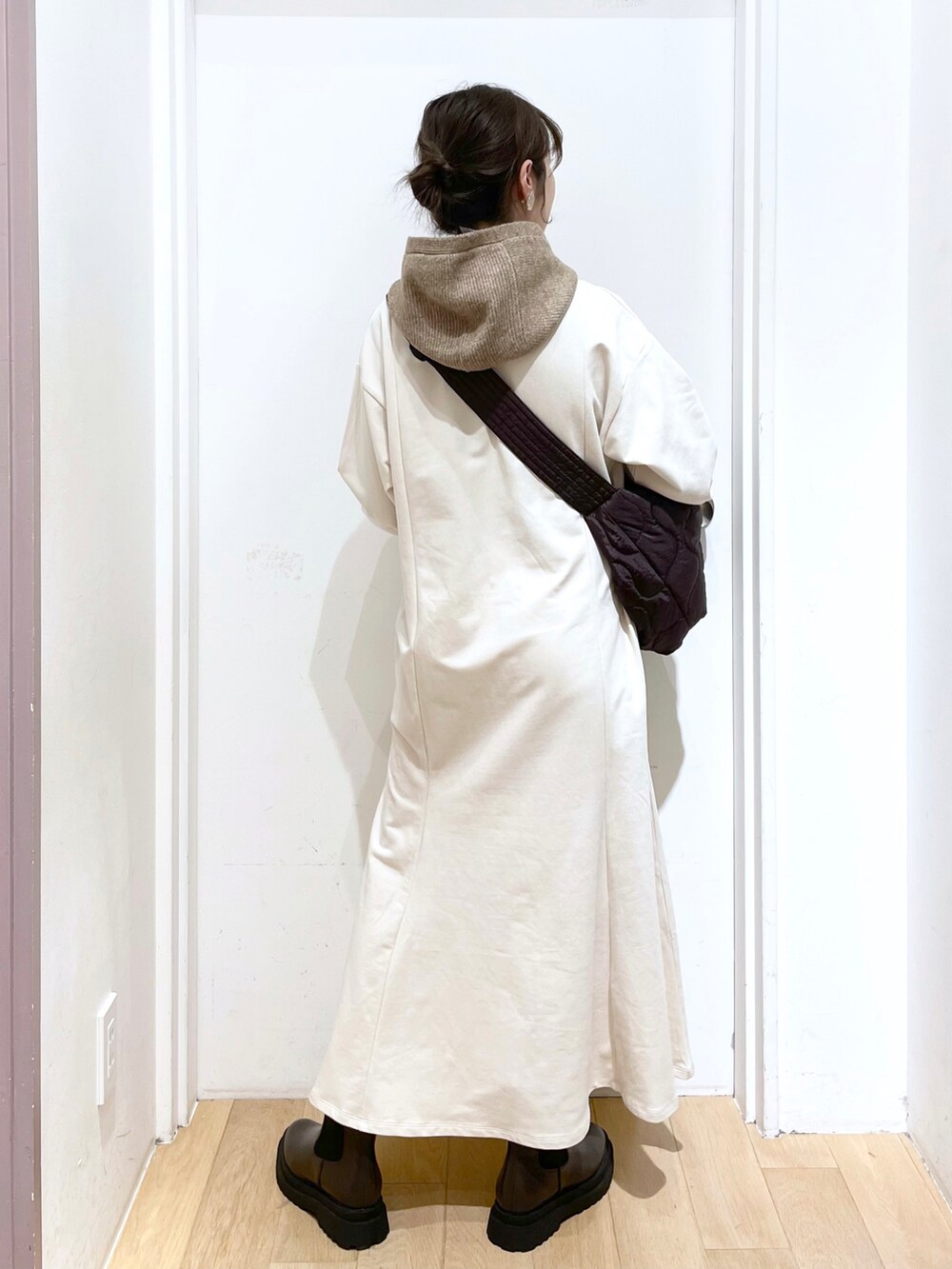 ブラウン系のブーツ、ホワイト系のワンピース、ブラウン系のショルダーバッグを着用したレディースの冬コーディネートの2枚目の写真