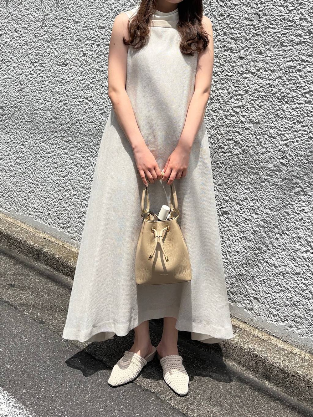 ベージュ系のワンピース、ホワイト系のTシャツ/カットソーを着用したレディースの夏コーディネートの4枚目の写真