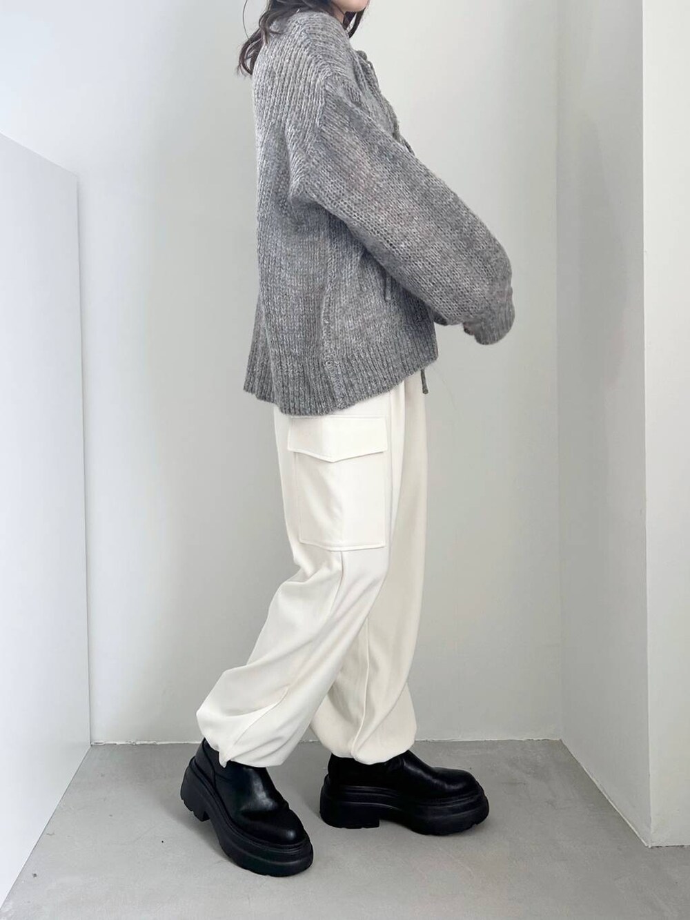 ホワイト系のキャミソール、ブラック系のブーツ、ホワイト系のカーゴパンツを着用したレディースの冬コーディネートの3枚目の写真